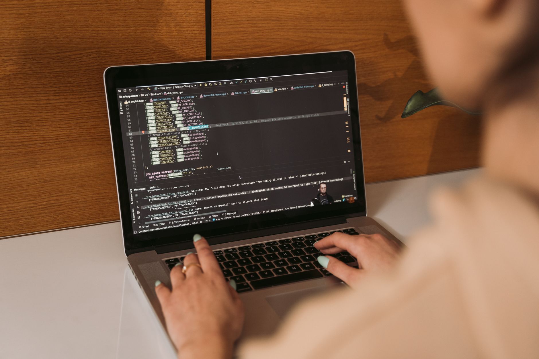 Close-up of a woman coding using a laptop in an office environment