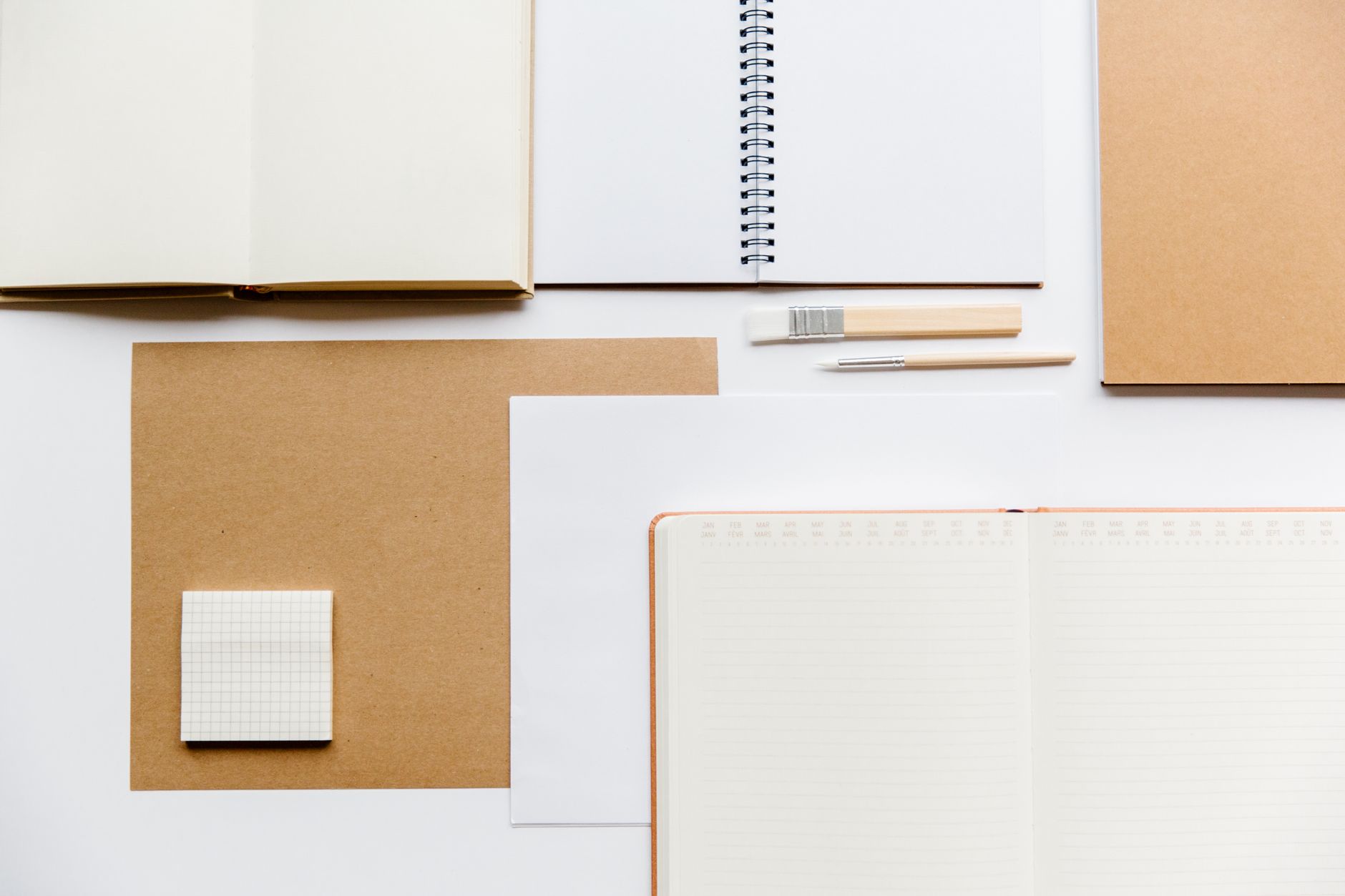 Flat lay of notebooks and stationery on a clean white background.